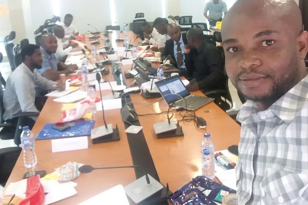 Client working session around a boardroom table with laptops and documents